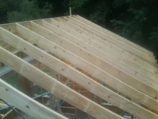 New roof rafters set over an addition before sheathing in Minetto
