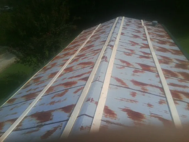 Rusted metal roof panels with new wood purlins before replacement — Storm Damage Roof Repair in Minetto by Roofing Brothers