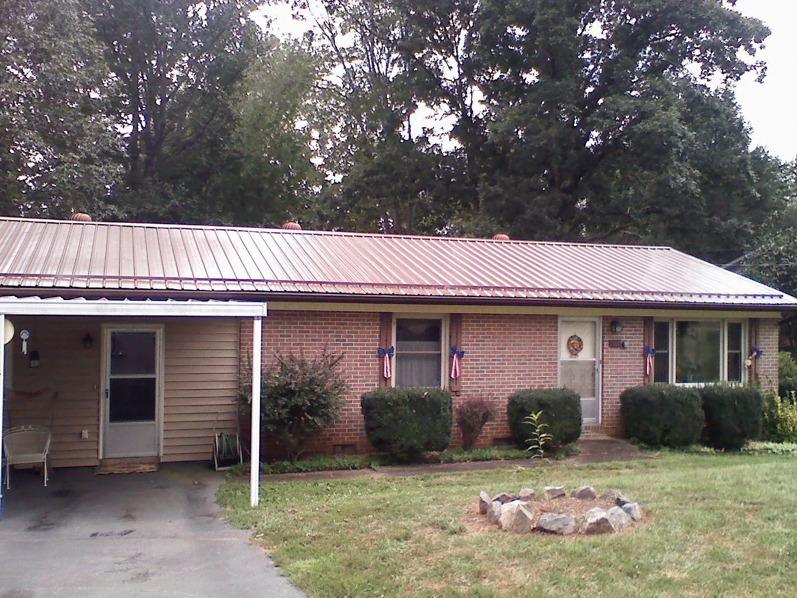 Bronze metal roof and carport on a brick ranch home — Roof Repair work by our crew in Minetto