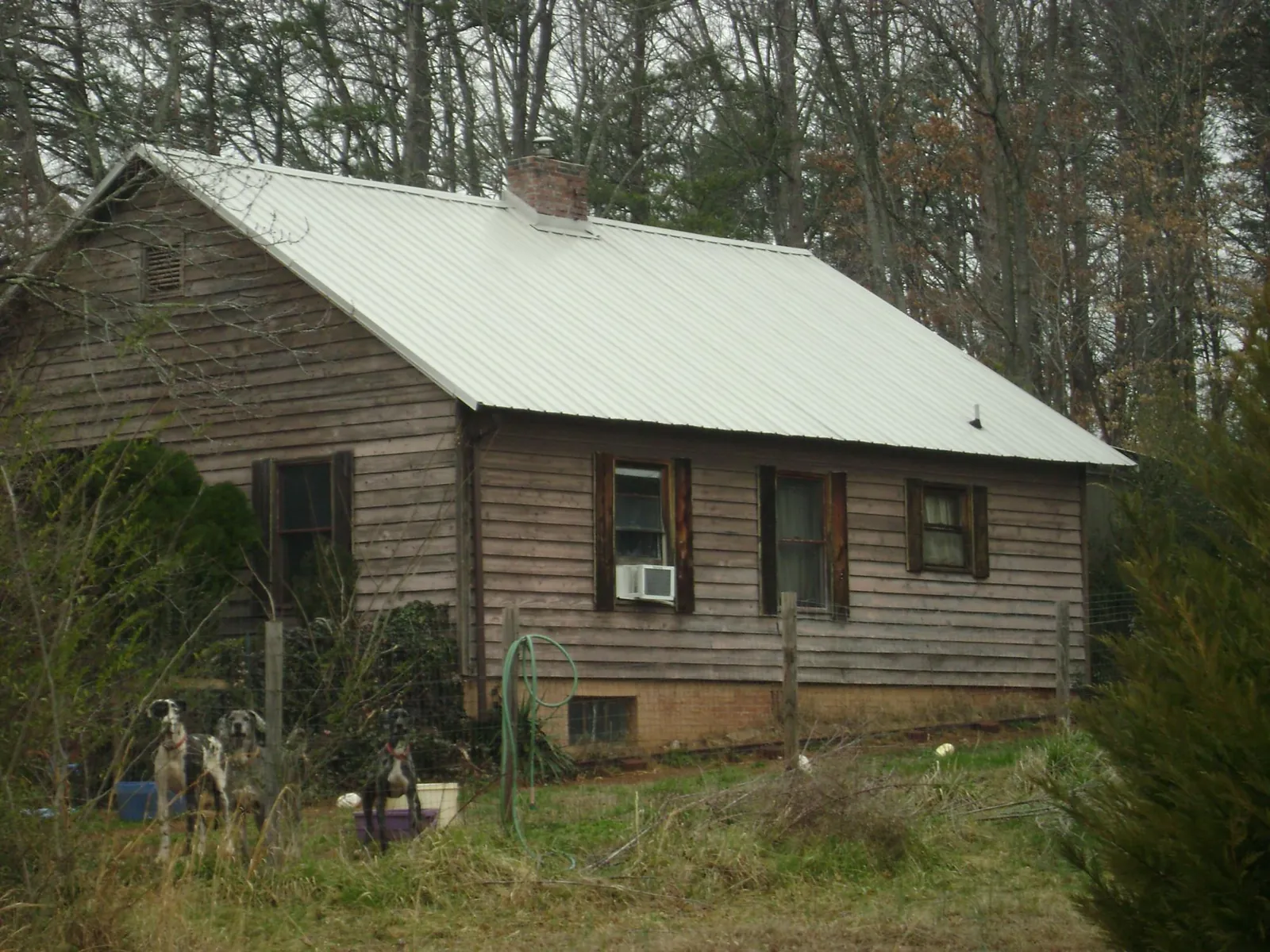 White metal roof on an old wood sided farmhouse, from a Metal Roof Installation job in Minetto